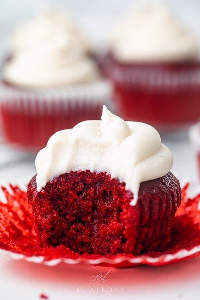 A vegan red velvet cupcake with a bite missing