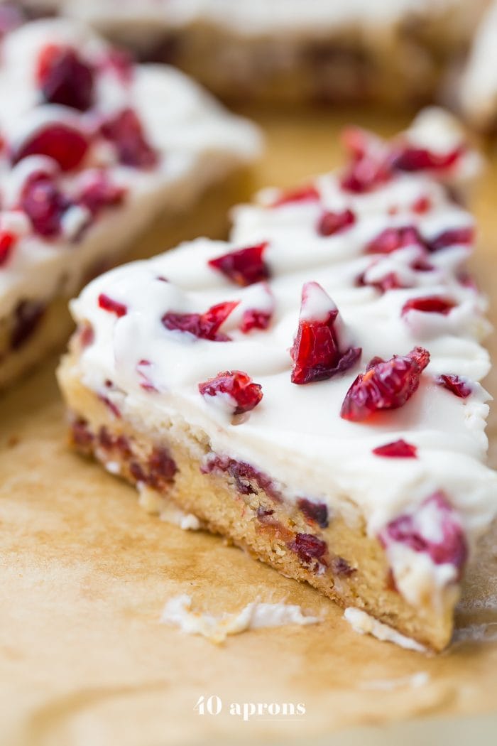 These paleo cranberry bliss bars are just that: bliss! These vegan cranberry bliss bars are a grain-, gluten-, and dairy-free paleo Starbucks copycat recipe that's perfect for the holidays. Blondies, layered with "cream cheese" frosting, topped with dried cranberries, these paleo cranberry bliss bars are so delicious. You'll love these vegan cranberry bliss bars because they're a holiday treat that are totally guilt-free!
