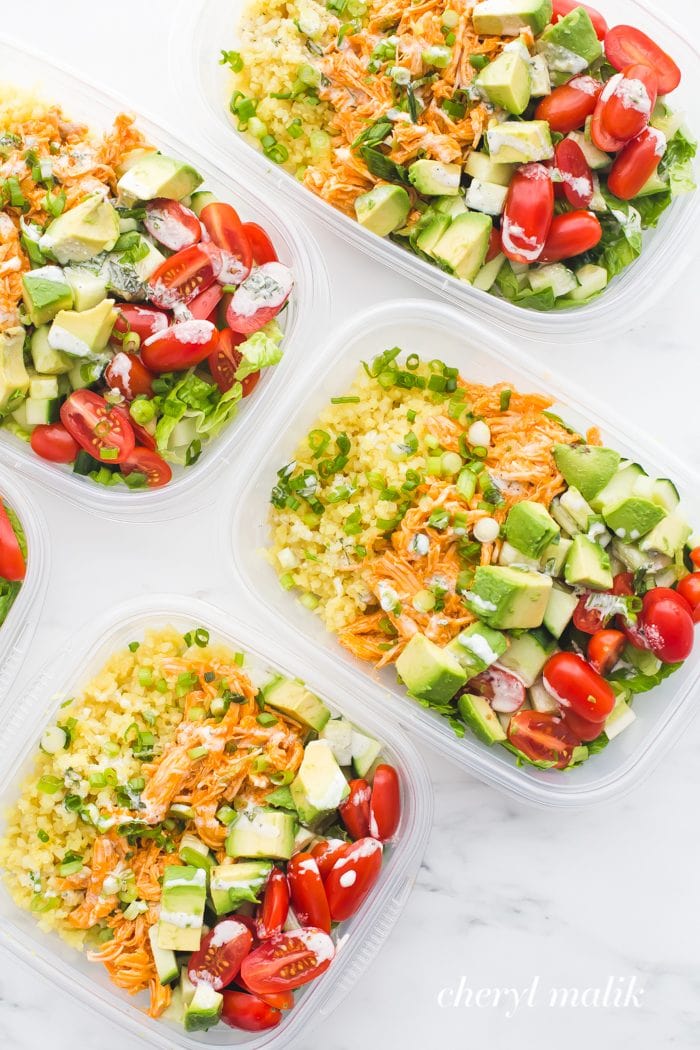 Buffalo chicken Whole30 meal prep recipe with avocado, cauliflower rice, and ranch dressing in container