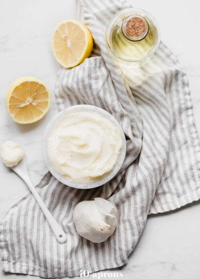 hole30 coconut oil mayonnaise in a bowl with lemons, garlic, and coconut oil