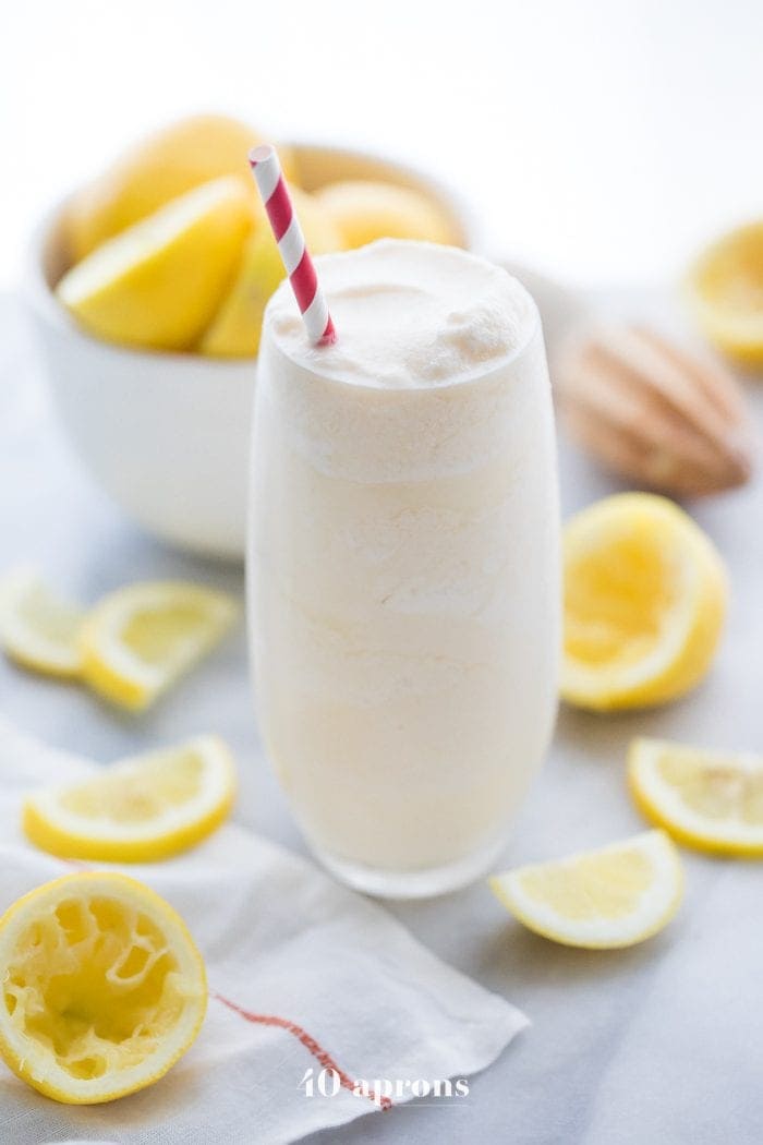 Healthy Chick Fil A frosted lemonade in a glass with a straw and lemons in the background