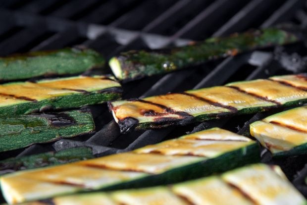 orange glazed zucchini slices cooking on a bbq grill