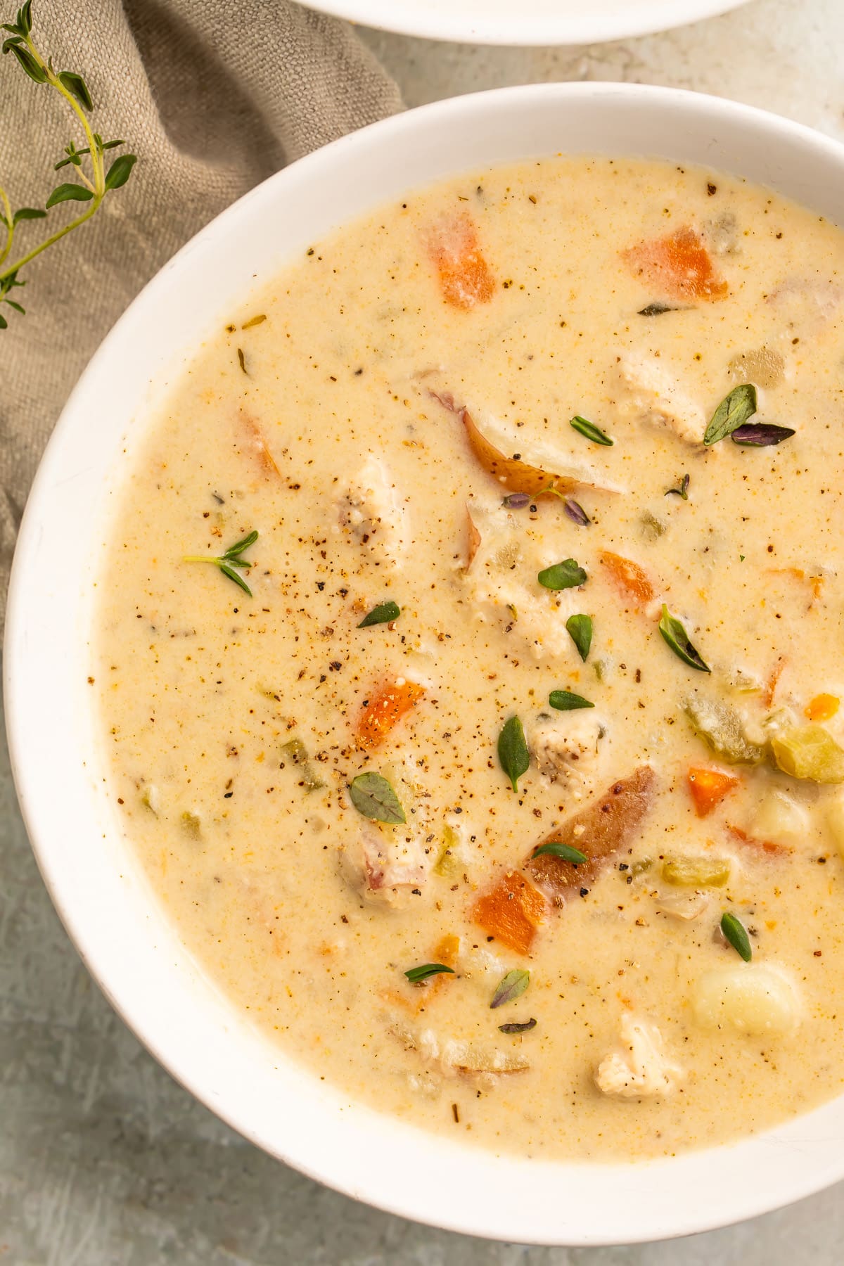 A white soup bowl, holding a creamy chicken pot pie soup made in the Instant Pot.