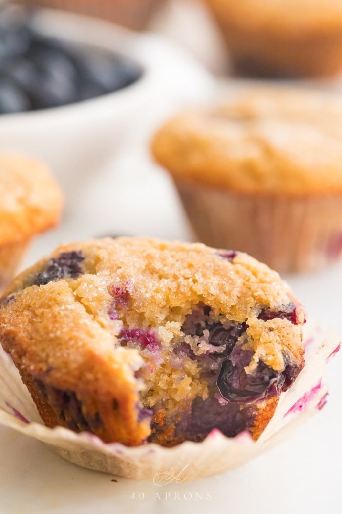 Paleo blueberry muffin with a bite out of it in front of other muffins