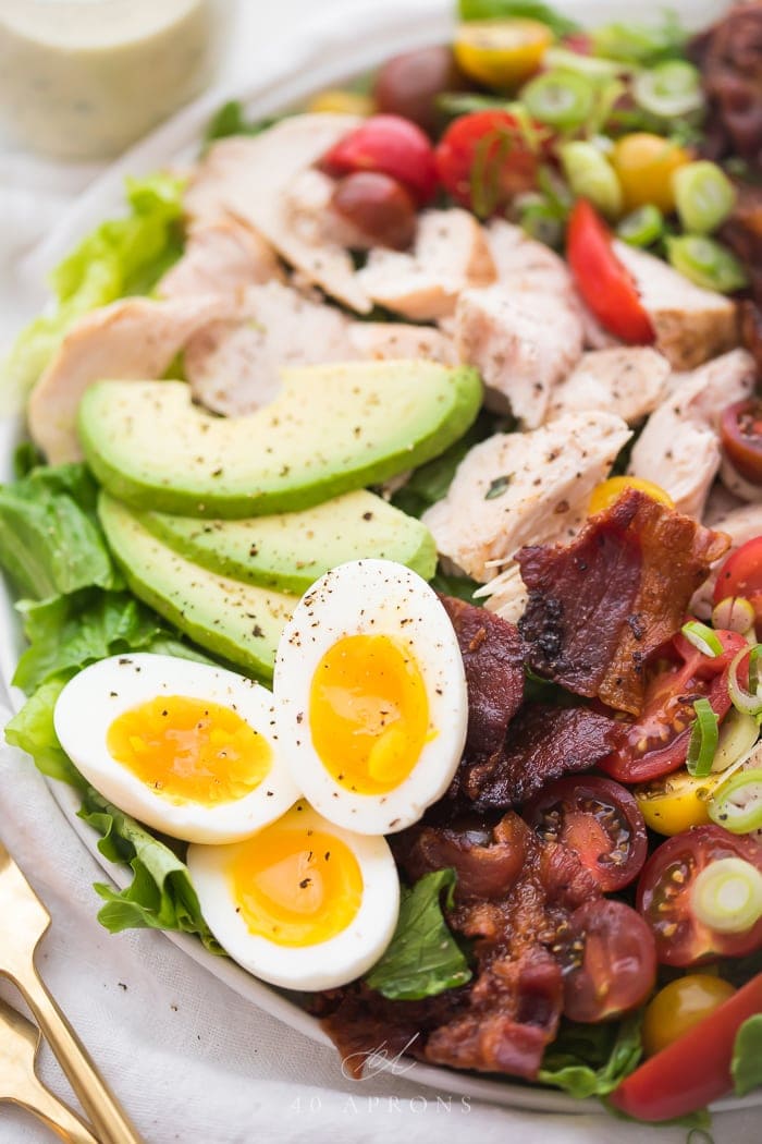 Close up on soft boiled eggs and bacon on classic chicken cobb salad