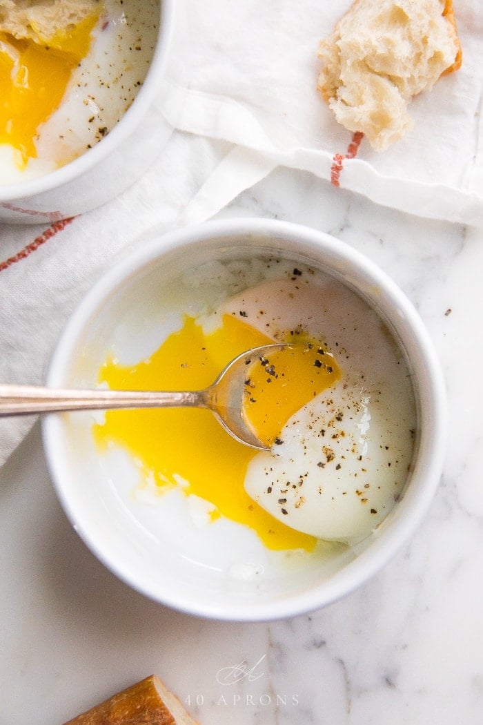 Sous vide eggs in a small white bowl with creamy runny yolks