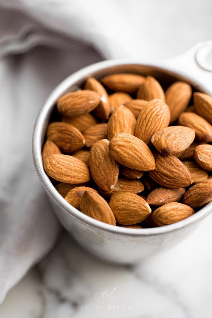 Silver measuring cup of almonds