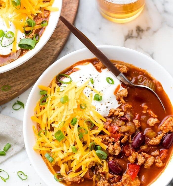 Turkey chili served in a white bowl with toppings