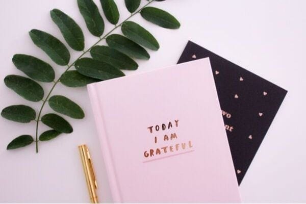 a gratitude journal with a golden pen on the side