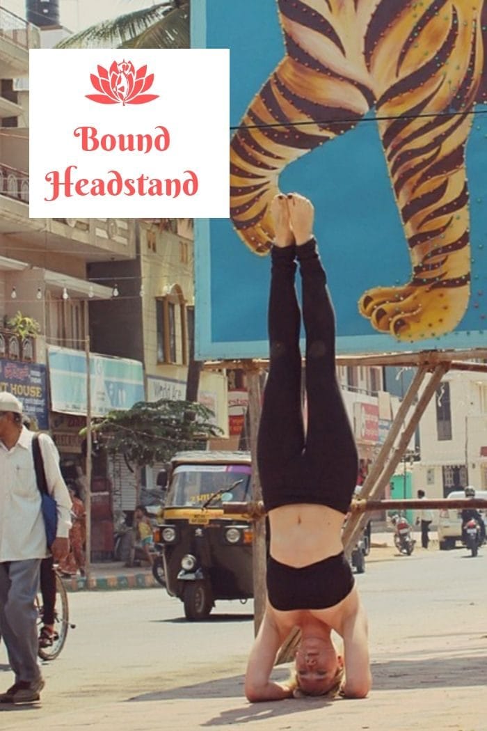 a blonde woman in black workout clothes performing a yoga bound headstand in the streets of Mumbai 