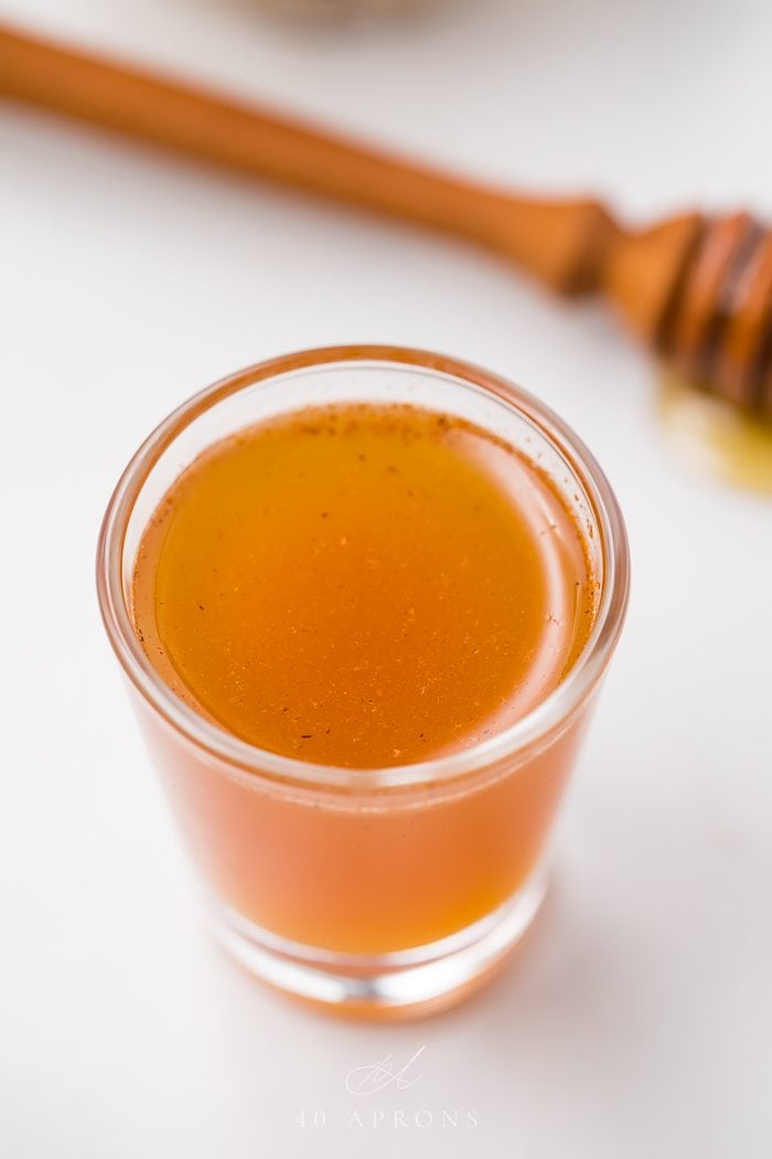 Close up of an apple cider vinegar shot on a white background