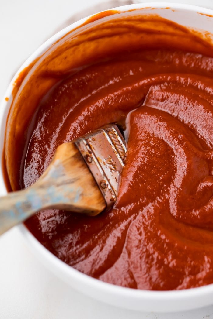 A bowl of Whole30 bbq sauce with a brush in it