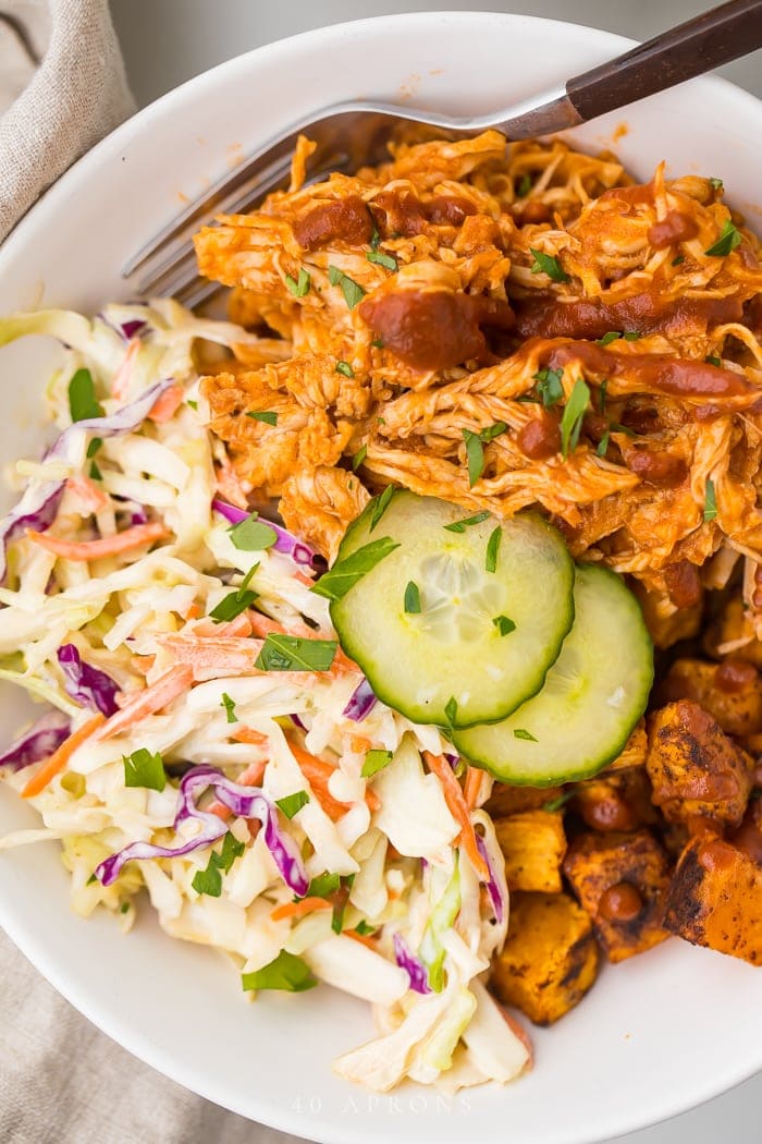 Close up of BBQ chicken bowl with sweet potatoes and coleslaw