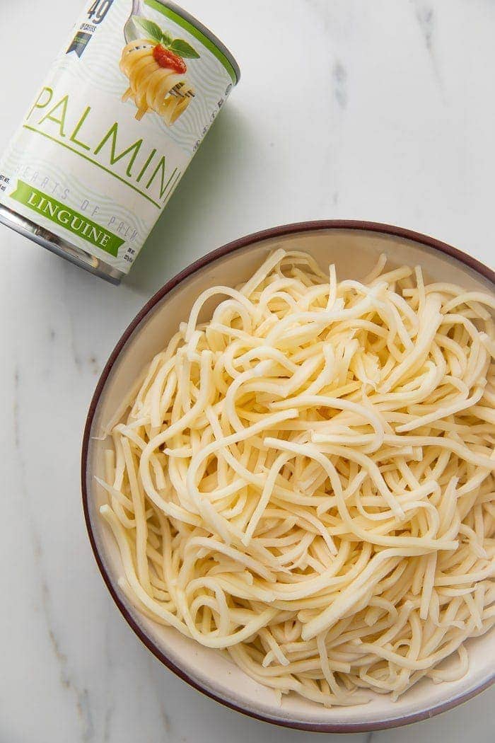 Bowl of palmini noodles next to a can of palmini