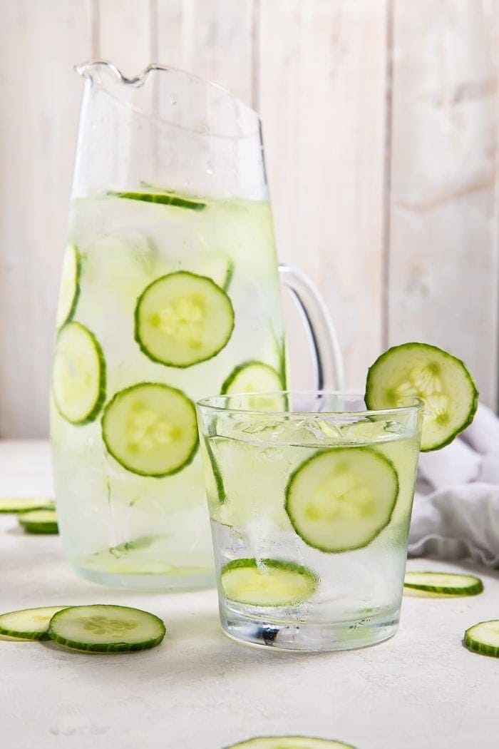 Pitcher and glass filled with cucumber water