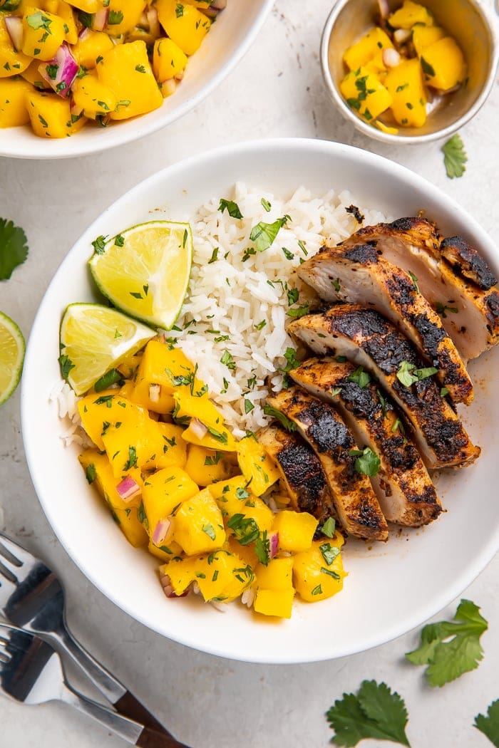 Overhead of jerk chicken bowl with coconut rice and mango salsa