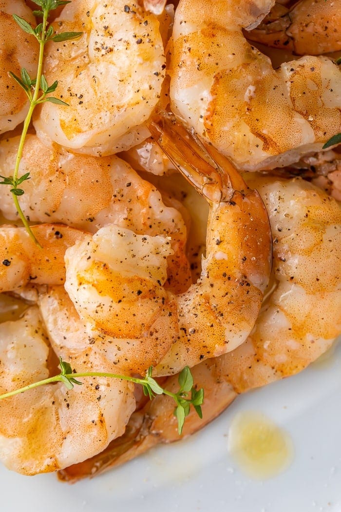 Close-up of cooked shrimp seasoned with pepper and garnished with parsley