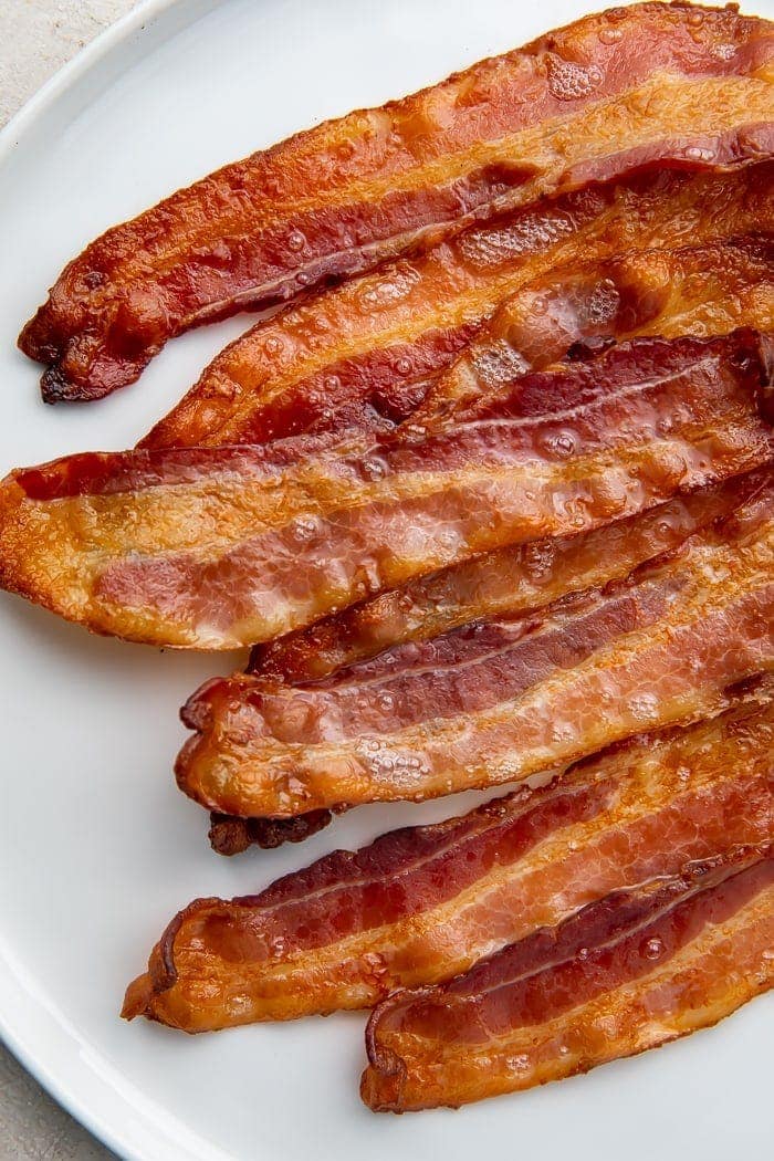 Oven-cooked bacon strips on a white plate