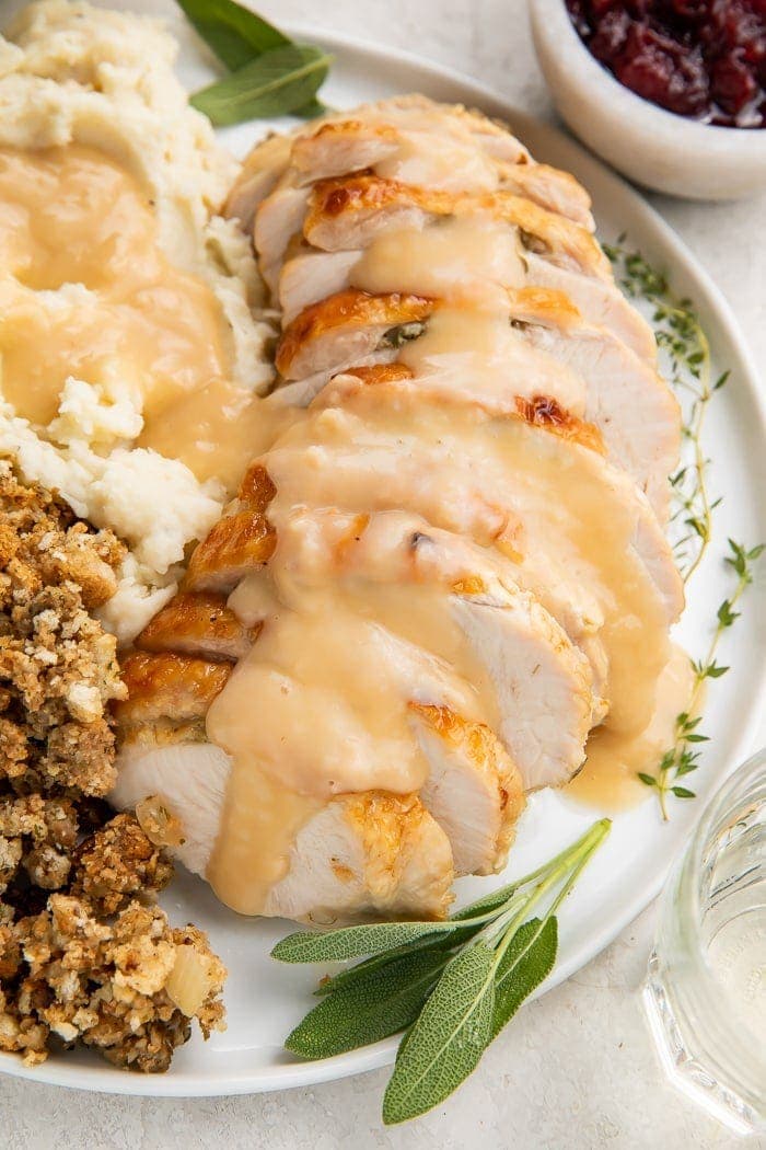 Instant Pot turkey breast slices covered with gravy on a plate