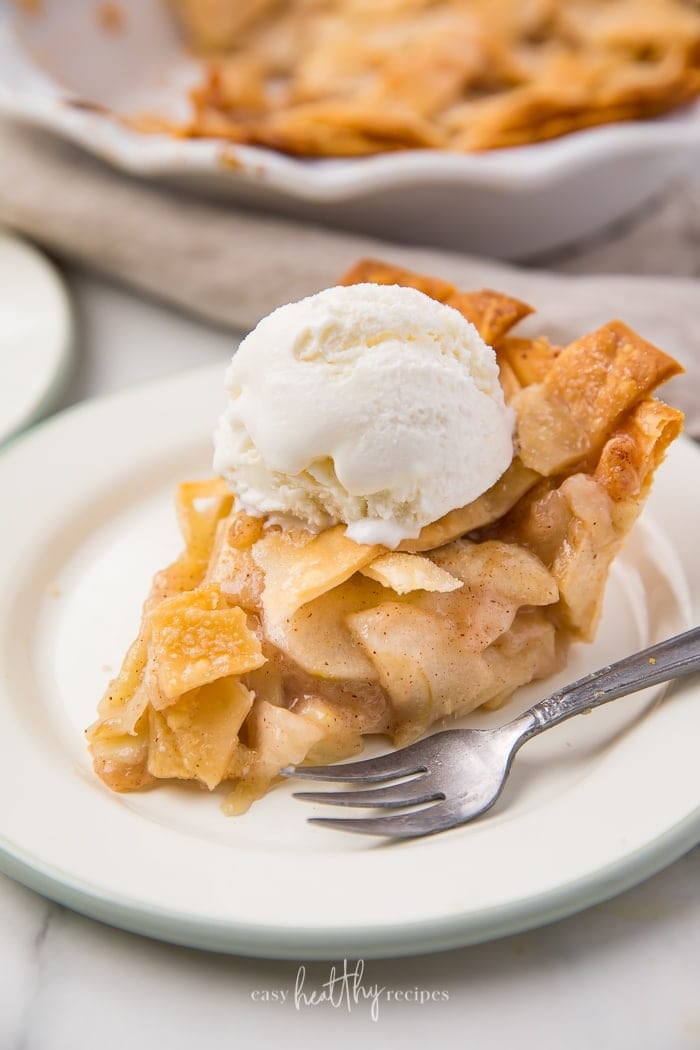 Classic homemade apple pie with vanilla ice cream on a white plate