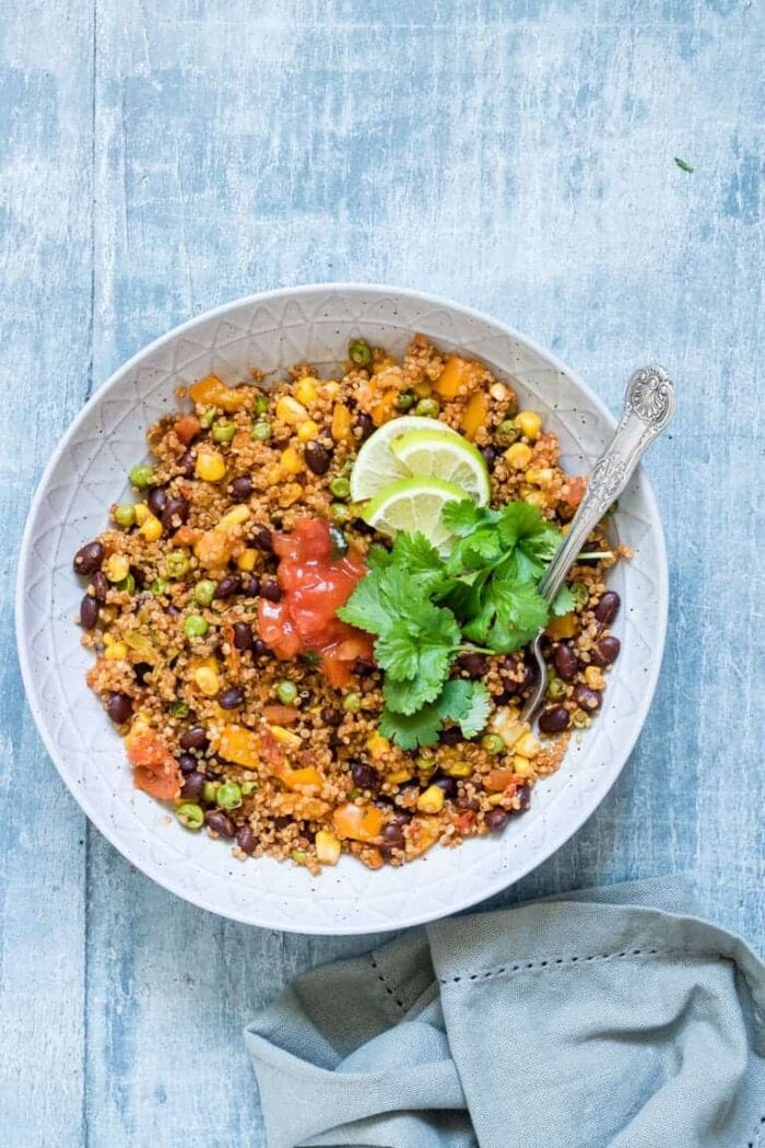 Instant Pot vegetarian Mexican quinoa in a white bowl against a blue background