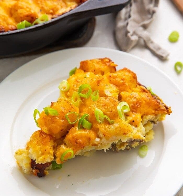 Wedge slice of tater tot breakfast casserole with sausage, egg, and cheese