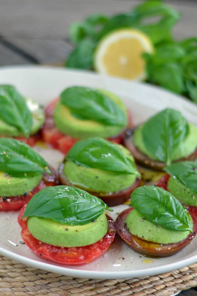 Tomato and avocado caprese on a white serving platter