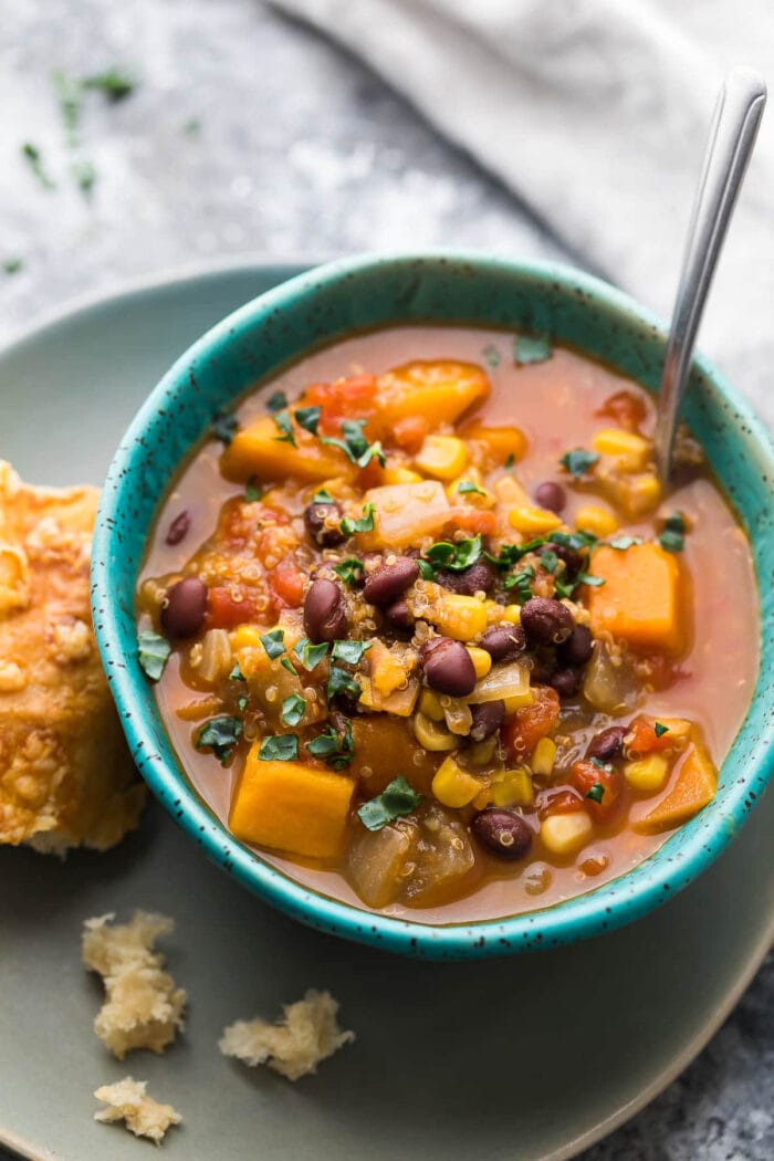 Vegetarian slow cooker black bean and quinoa stew with sweet potatoes in a blue bowl