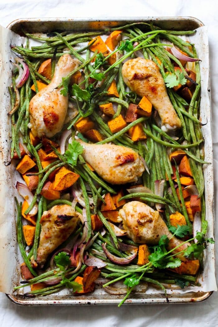 Chicken drumsticks and green beans on a sheet pan