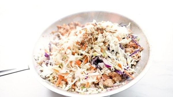 Slaw mix, ground pork, onions, garlic, and coconut aminos in a large skillet