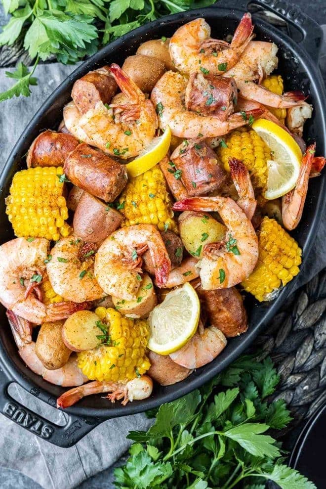 Instant Pot shrimp boil - shrimp, potatoes, corn, lemon on a black platter