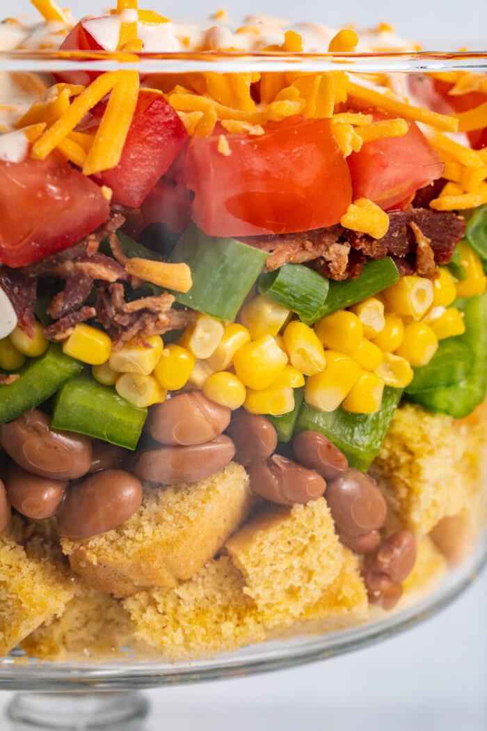 Close up image of cornbread salad layered in a dish.