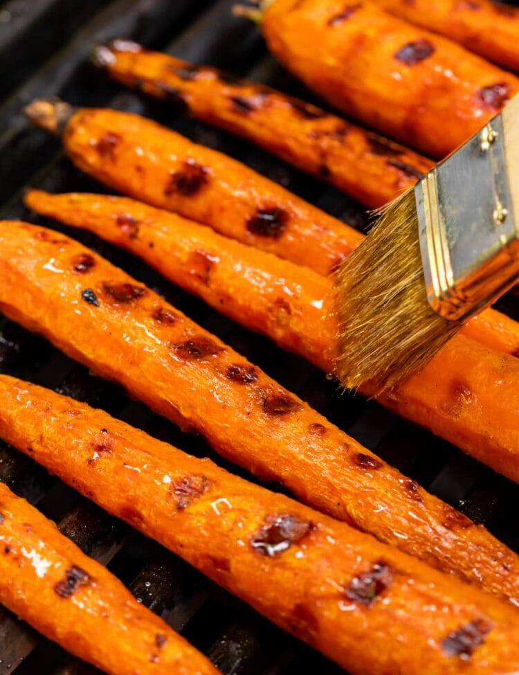 maple syrup being brushed on maple glazed grilled carrots