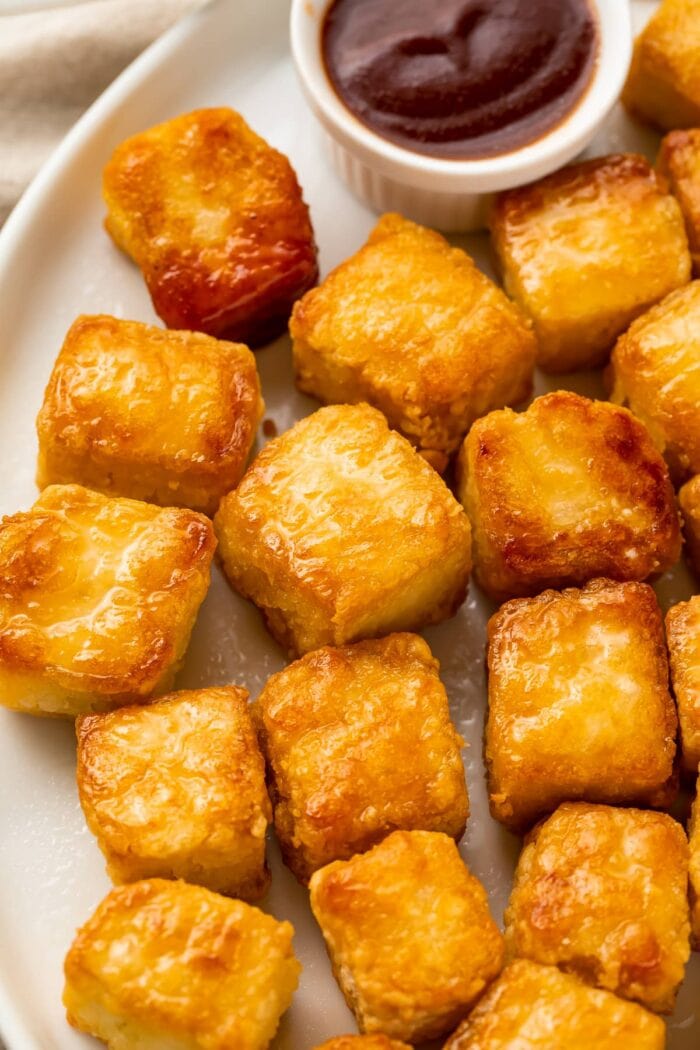 Close up view of crispy baked tofu cubes on a white plate