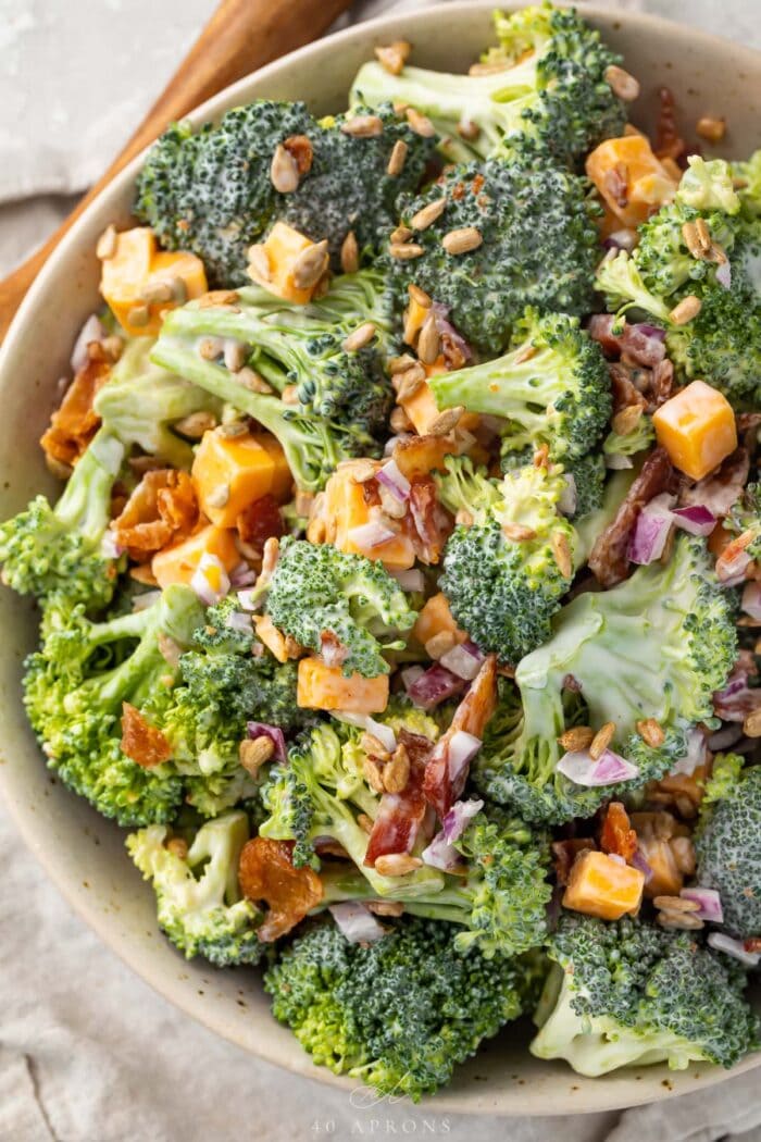 Keto broccoli salad in a large bowl on a table next to a wooden spoon