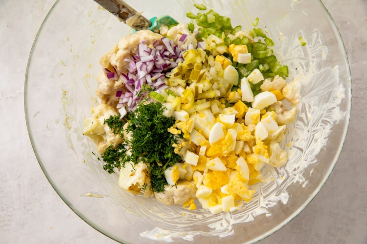 Cauliflower potato salad ingredients in a glass mixing bowl