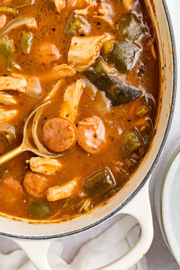 chicken and sausage gumbo in a large pot with a spoon