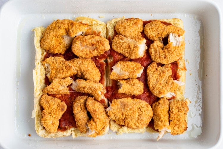 Crispy chicken strips on top of sweet rolls and marinara sauce