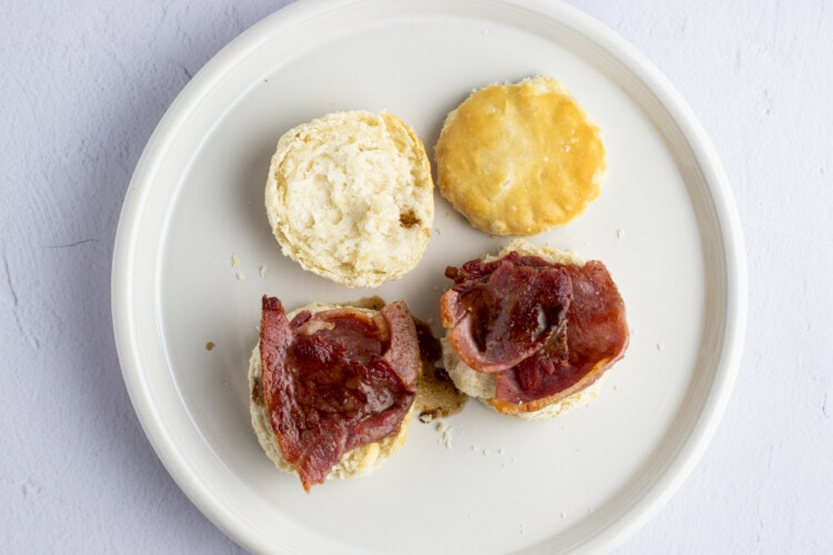 Ham and biscuits with red eye gravy on white plate