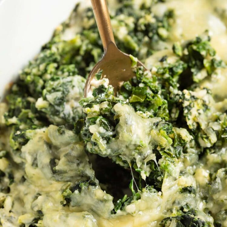 spinach casserole being scooped out of the baking dish.