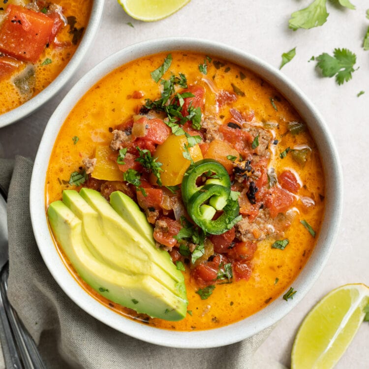 overhead image of whole30 creamy taco soup with sliced avocado and jalapenos on top