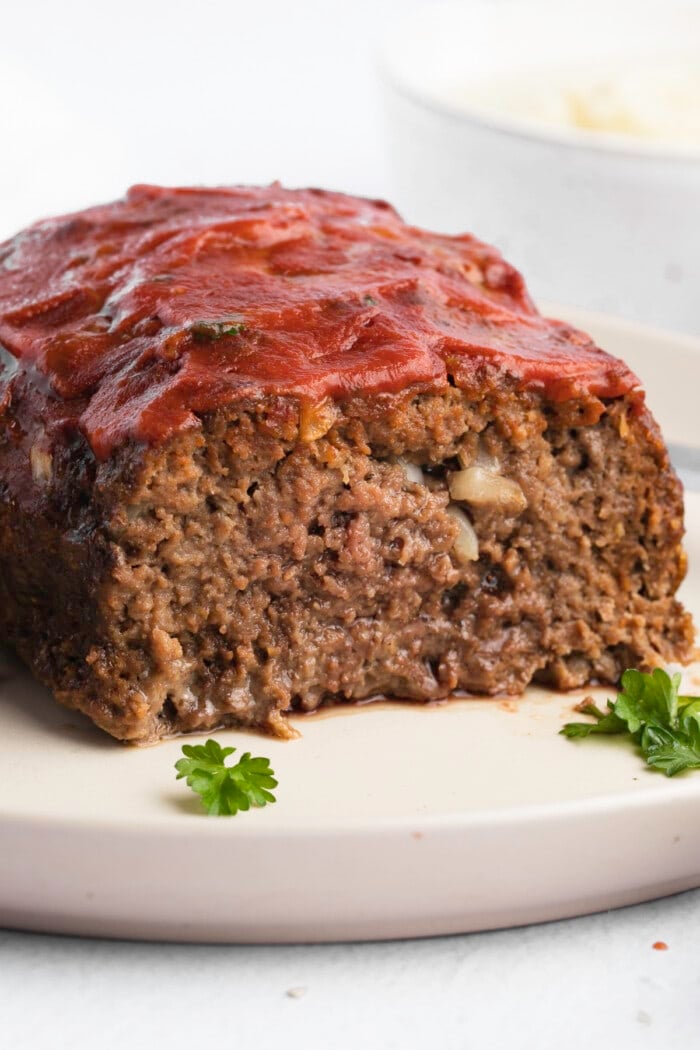 A closeup of a sliced loaf of paleo meatloaf on a plate