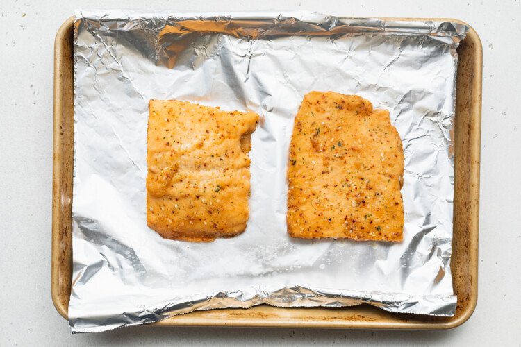 Two Sea Cuisine teriyaki sesame salmon fillets on a baking sheet lined with aluminum foil.