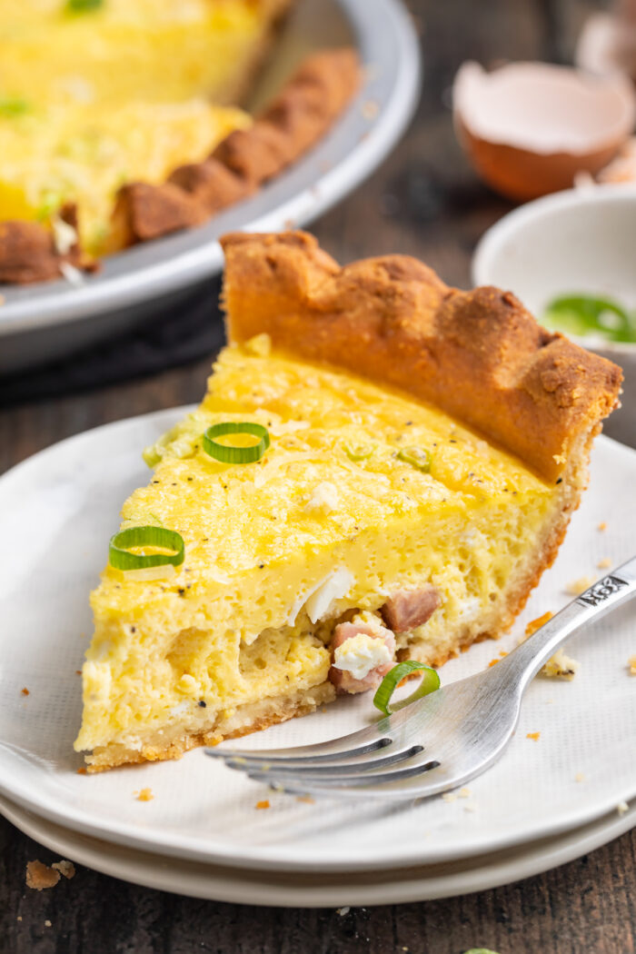 Side view of a slice of keto quiche on a plate with a silver fork.
