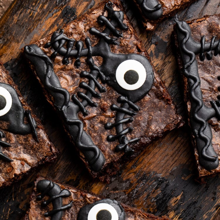 Close-up of one Hocus Pocus spellbook brownie out of 5 on a wooden tray surrounded by Halloween imagery.