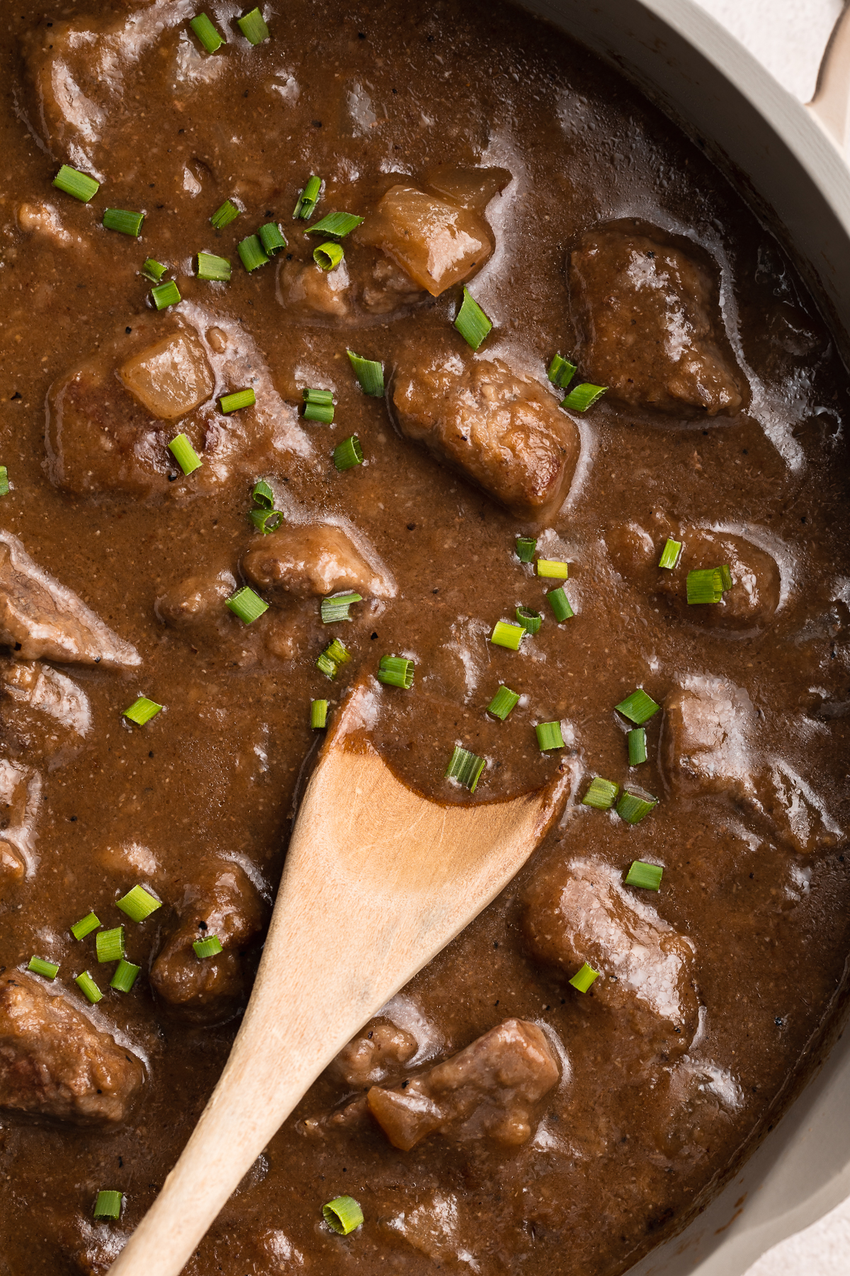 Overhead view of a large skillet holding cook beef tips and rich dark gravy.