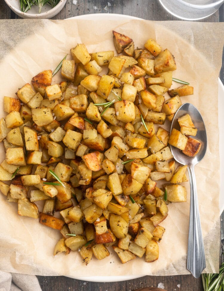 Overhead view of diced potatoes in a large bowl lined with parchment paper.