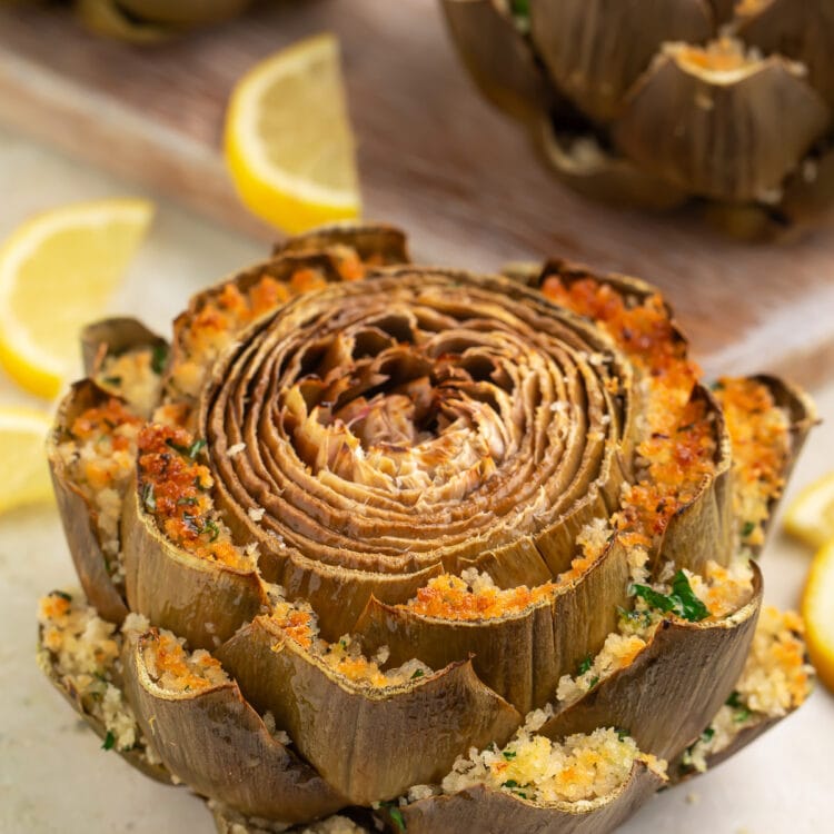 Green steamed artichokes stuffed with a baked cheese and breadcrumb mixture between each petal.
